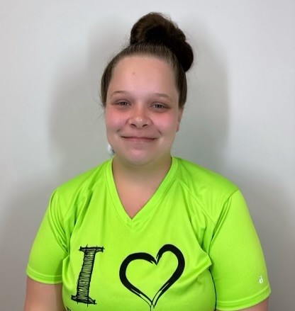 A young woman wearing a green t - shirt.