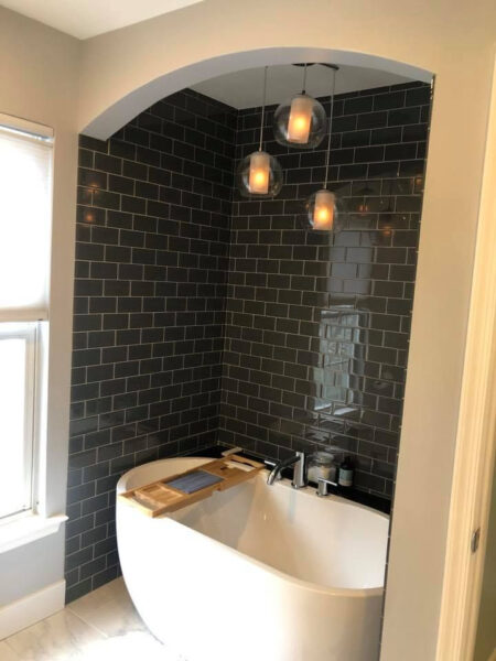 A bathroom with a bathtub and a window.